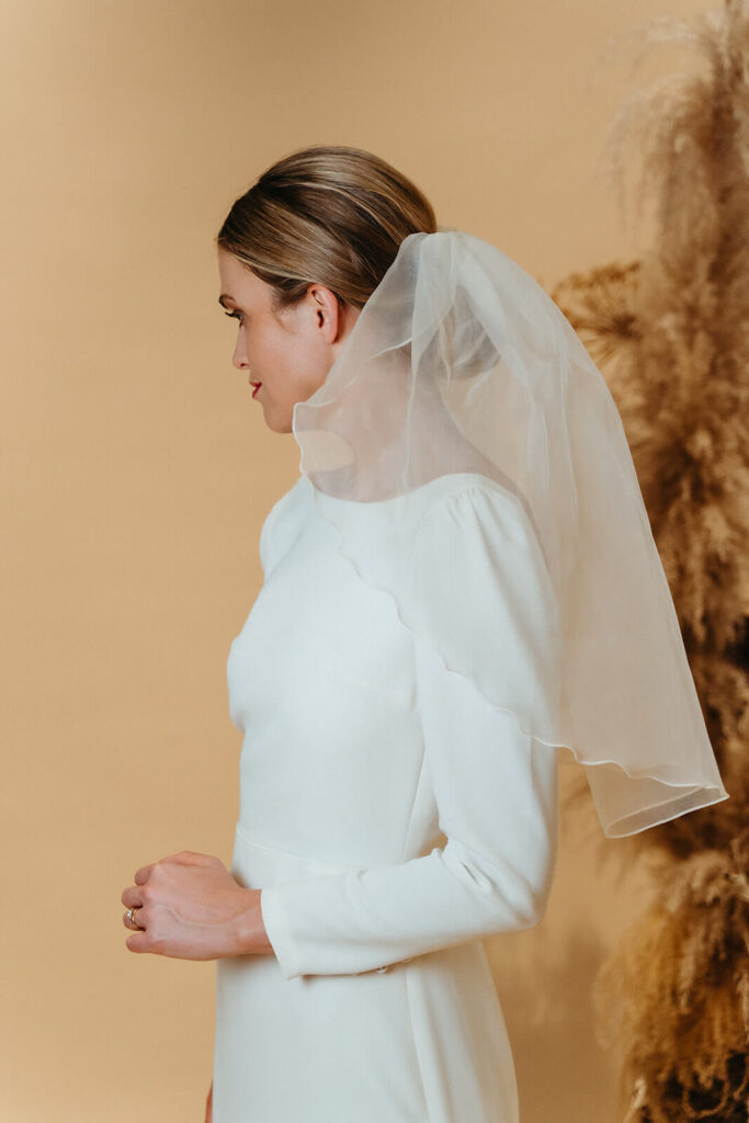 moderne og enkel brudekjole med lange ærmer og kort slør
